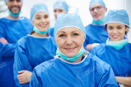 Preview: Medical Team Smiling While Wearing Scrubs and Surgical Caps