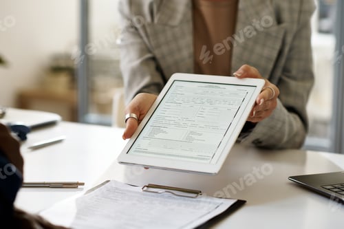 Preview: Businesswoman showing contract on tablet pc to client