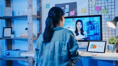 Preview: Asia businesswoman using desktop talk to colleagues in video call meeting at living room.