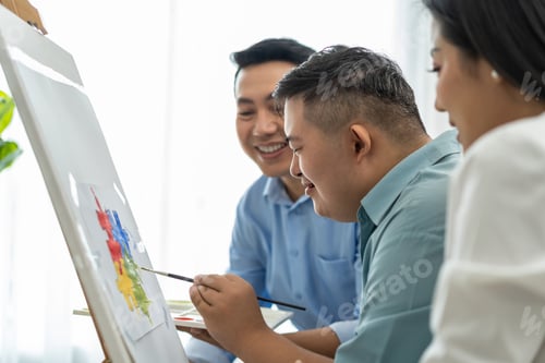 Preview: Asian happy family draw picture with down syndrome son in living room.