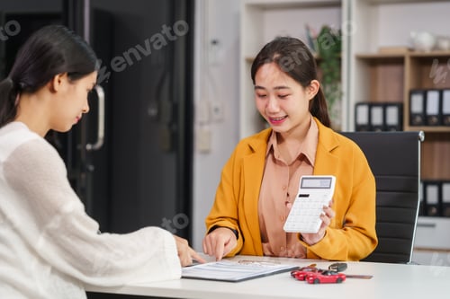 Preview: Asian businesswoman and a salesman discuss car sales, insurance, financing a customer at a desk