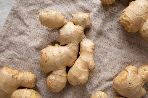 Preview: Raw Organic Ginger Root on cloth, top view. Flat lay, from above, overhead.