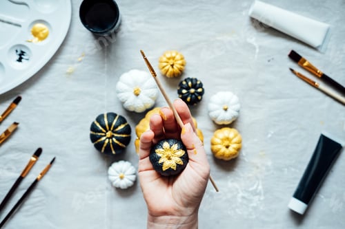 Preview: Female hands with painting pumpkins. Creative pumpkin painting ideas for Halloween and Thanksgiving