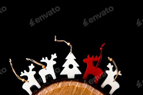 Preview: Red and white felt rein deers isolated on black. Christmas background with handmade ornaments