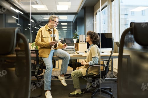 Preview: Confident mature male manager talking to younger colleague