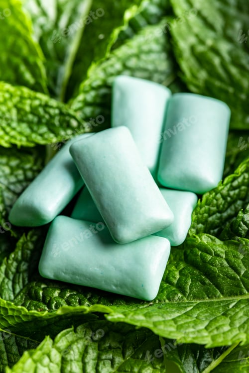 Preview: Mint chewing gum pads on green mint leaves.