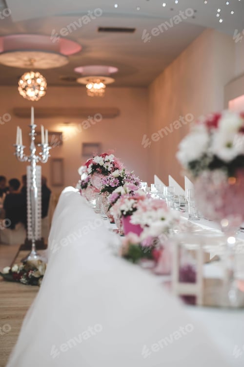 Preview: Vertical shot of beautiful bouquets of flowers placed on a white table at the wedding ceremony