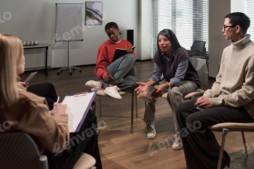 Preview: Diverse Adults Engaging in Group Therapy Session and Sharing Experiences