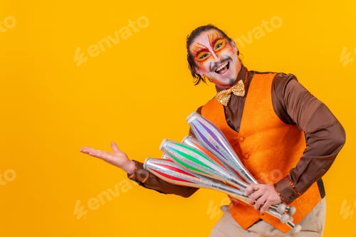Preview: Cheerful circus performer skillfully holding a number of clubs isolated on yellow background