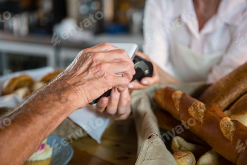 Preview: Customer making payment through NFC technology on mobile phone