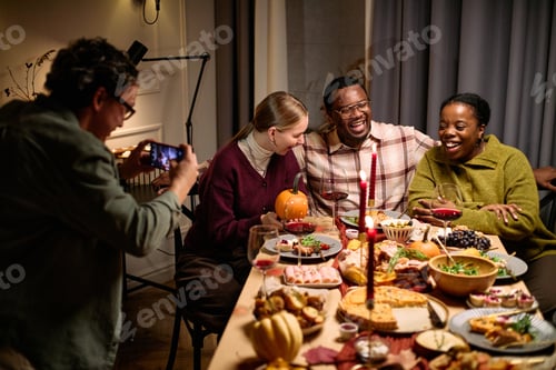 Preview: Diverse Friends Taking Photos while Sharing Thanksgiving Dinner Together
