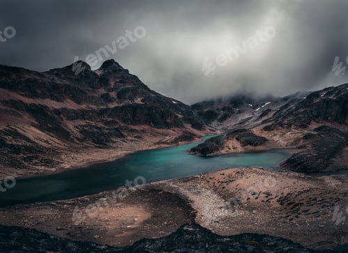 Preview: Lake among rocky foundations under cloudy sky