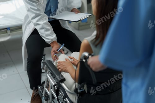 Preview: Doctor explaining diagnosis to young woman in wheelchair in hospital room