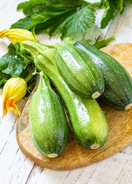 Preview: Fresh healthy green zucchini on a wooden kitchen table.