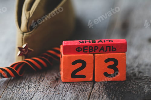 Vista previa: Wooden calendar with the date of February 23, St. George ribbon, garrison cap.