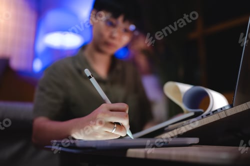 Preview: Late-night freelancer, Dedicated Asian woman working overtime on laptop computer, meeting deadlines