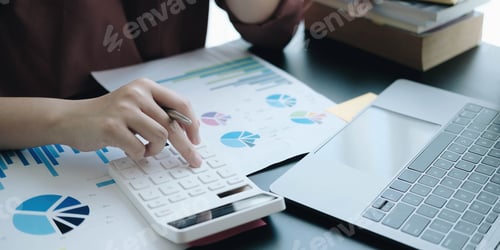 Preview: Close up Business woman using calculator and laptop for do math finance on wooden desk in office and