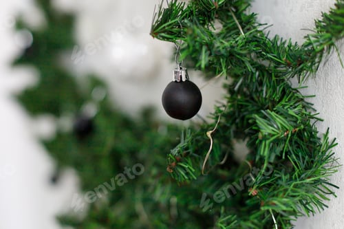 Preview: Christmas tree branches decorated with black and white balls on a white background
