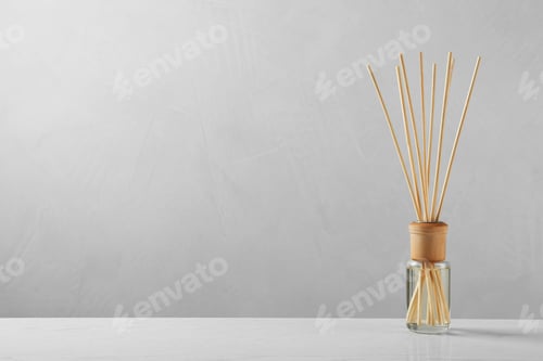 Preview: Reed air freshener on table against grey background, space for text