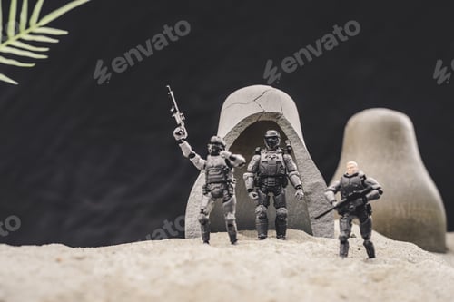 Preview: toy soldiers with guns and american flag standing near caves on sand dune on black background