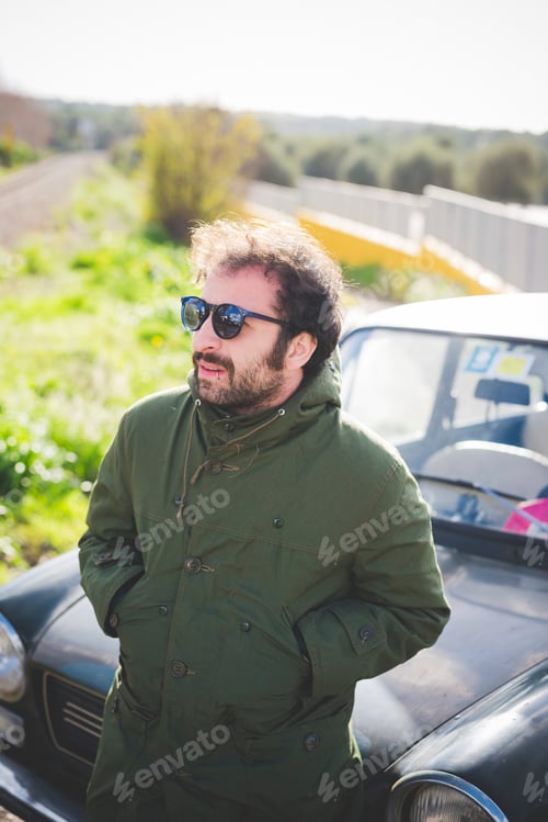 Preview: Mid adult man in front of vintage car