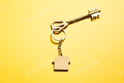 Preview: Key chain in the shape of wooden house with key on a yellow background