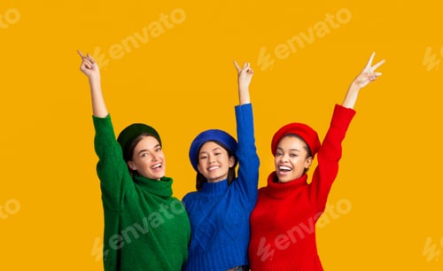 Preview: Positive Girls Gesturing V-Sign Smiling Posing Over Yellow Background