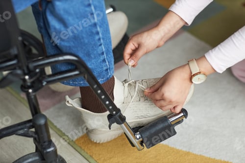 Preview: Woman helping man with disability to tie shoelace
