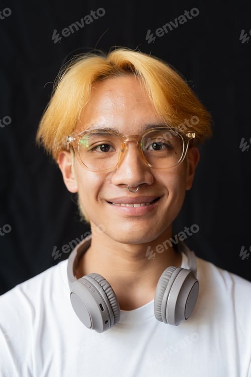 Preview: Studio portrait of young gay man with septum piercing ring and headphones
