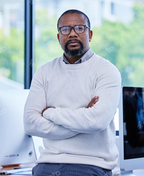 Preview: Portrait of a mature businessman standing with his arms crossed in an office