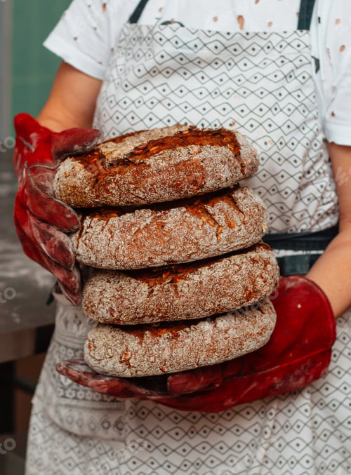 Preview: loaves of fresh bread in the baker's hands