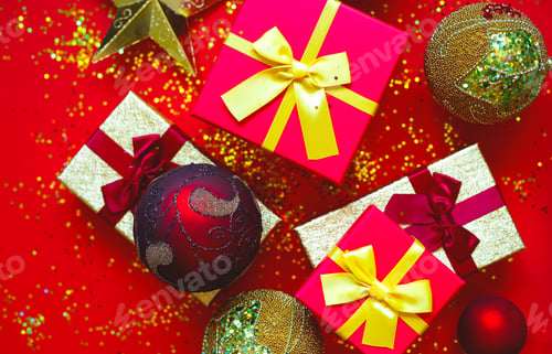 Preview: gift boxes with bows and Christmas toys on a red-gold background
