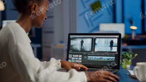 Preview: African videographer working at laptop from office editing video project