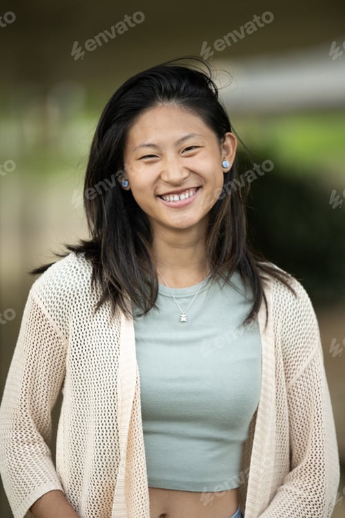 Preview: Beautiful cheerful young lady looking at camera standing outside.Joyful happy woman laughing staring