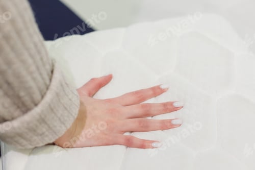 Preview: Woman's hand pressing on white mattress. Checking hardness and softness