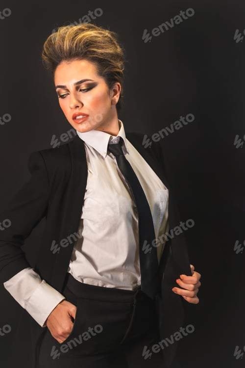 Preview: A sexy young blonde hair female in a black suit posing in studio