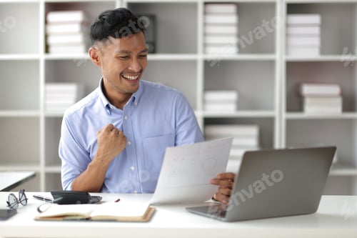 Preview: Portrait of a young businessman working happily in the office.