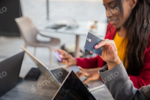 Preview: Close-up of a credit card held by a woman shopping online with her friend, photo with copy space.
