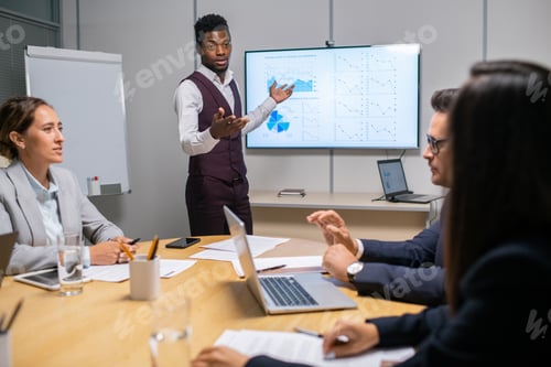Preview: Young confident speaker or coach making report in front of audience