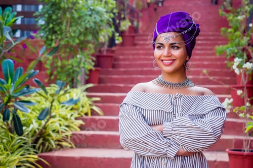 Preview: African woman in a dress with a colorful traditional shawl on her head.