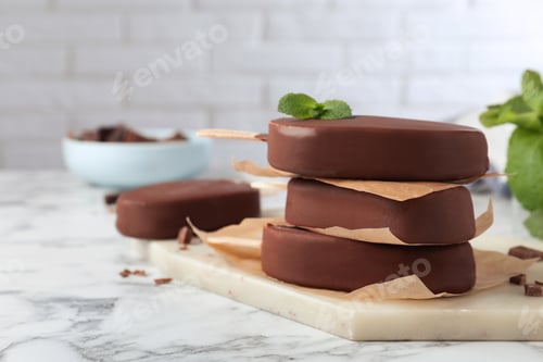 Preview: Delicious glazed ice cream bars with mint on white marble table. Space for text
