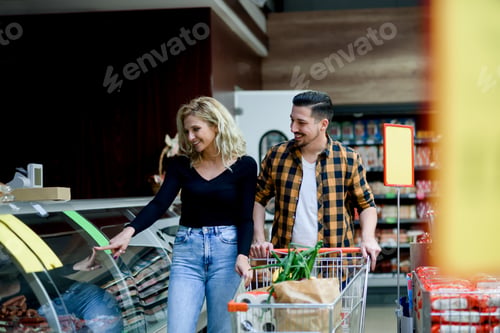 Preview: Couple in a supermarket with shopping cart while grocery shopping
