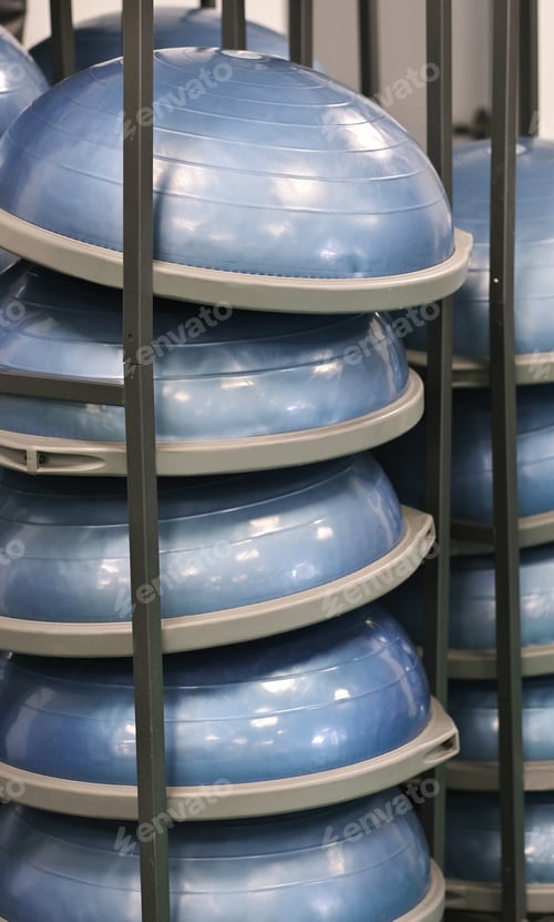 Preview: bosu balance balls stacked on a wall holder in a gym or fitness hall. bosu fitness trainer.