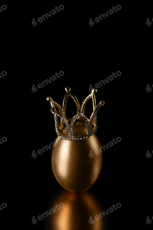 Preview: Golden egg in a crown on a black background close up