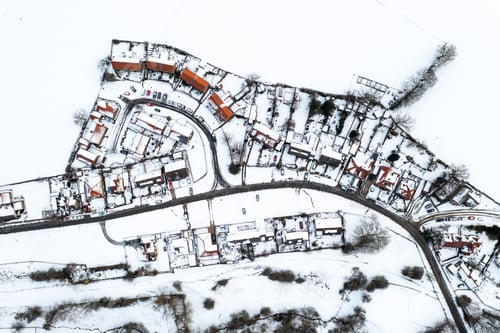Preview: Aerial view directly above snow covered homes in a village community