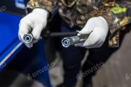 Preview: man is holding a high pressure hose with fittings