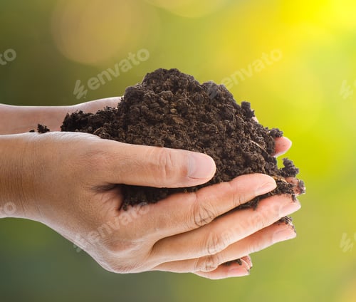 Preview: Handful of black soil over nature background