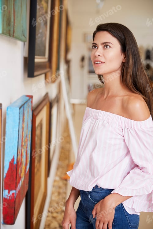 Preview: Woman Looking At Paintings In Art Gallery