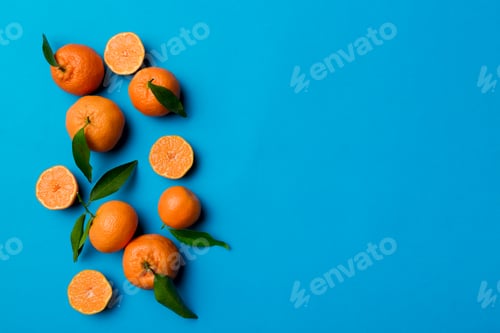 Preview: Many fresh ripe mandarin with green leaves on colored background, top view, space for text