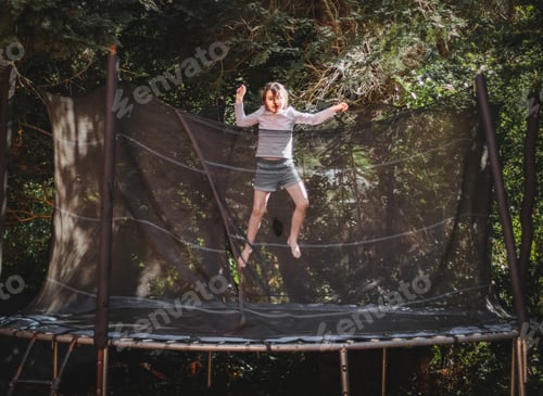 Preview: A beautiful caucasian girl in shorts and a t-shirt with sleeves jumps on a trampoline